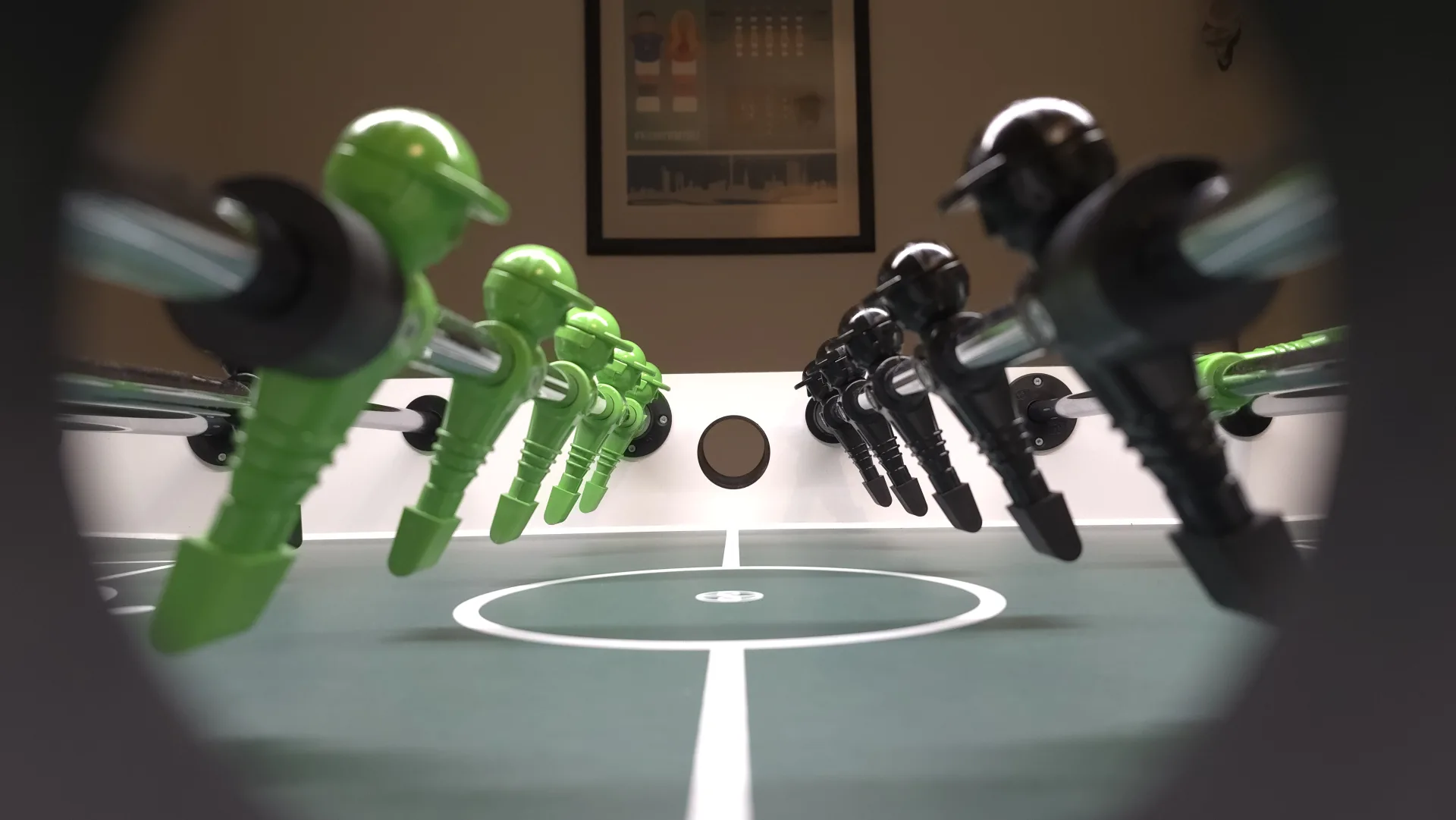 Blick durch das Balleinwurf-Loch eines Kicker-Tisches auf Mario Christ