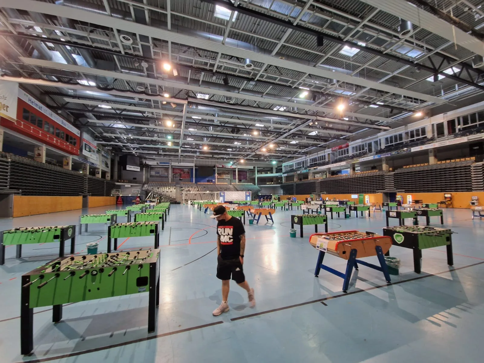 Riesige Sporthalle mit dutzenden aufgebauten Kicker-Tischen – Weitwinkelblick auf ein professionelles Tischfußball-Turnier